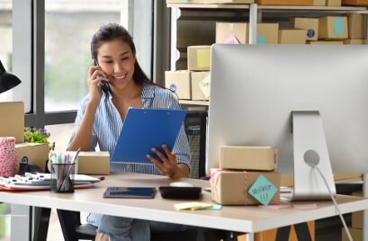 Jovem Sorridente no Telefone com Tablet na mão - Fagg Contabilidade para E-commerce